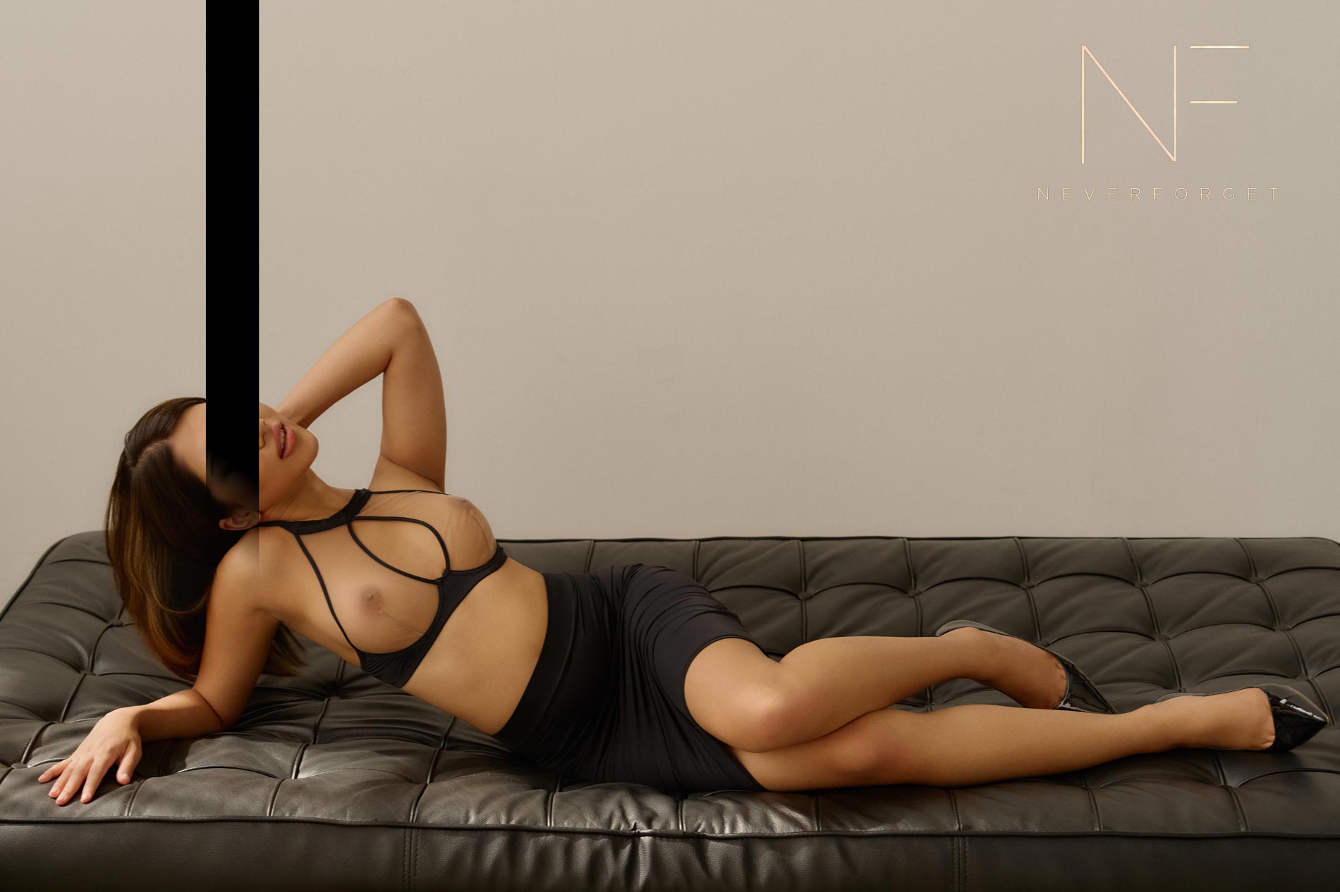 Escort Mika aus Hamburg liegend in schwarzem Rock und BH